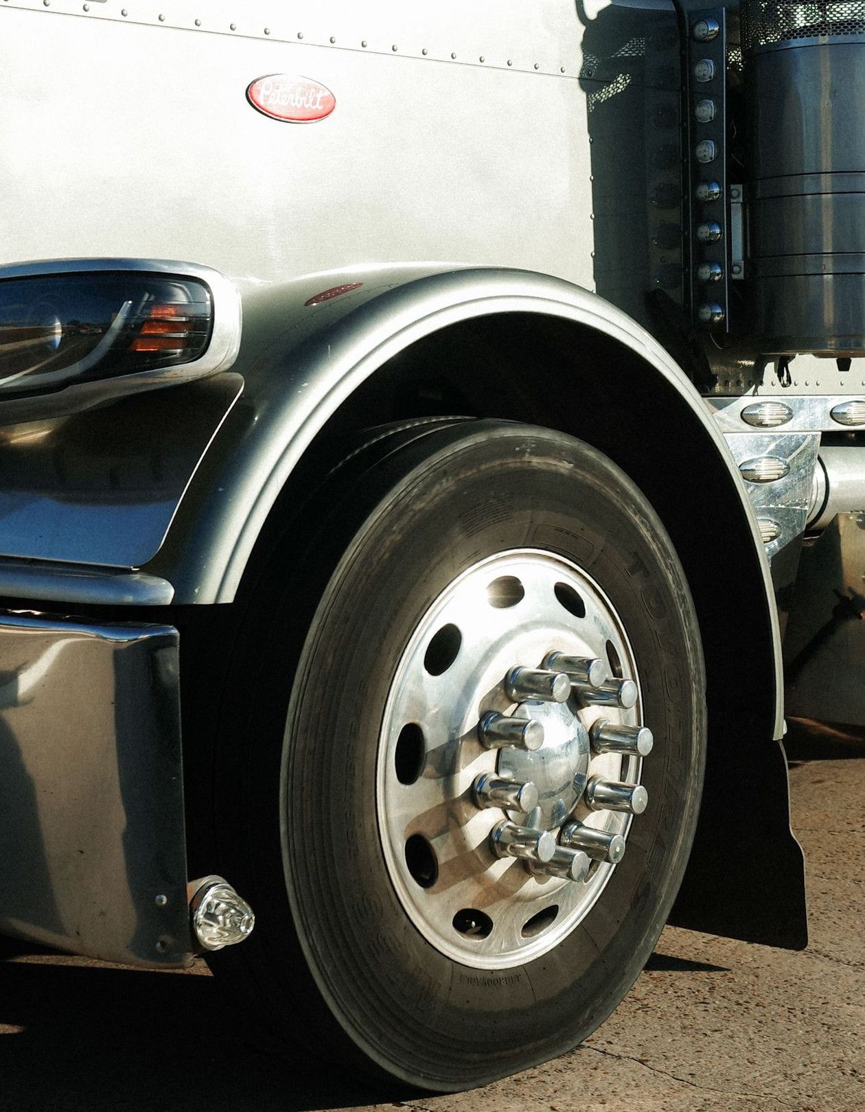 A gleaming silver semi-truck parked under bright daylight in Houston, Texas.